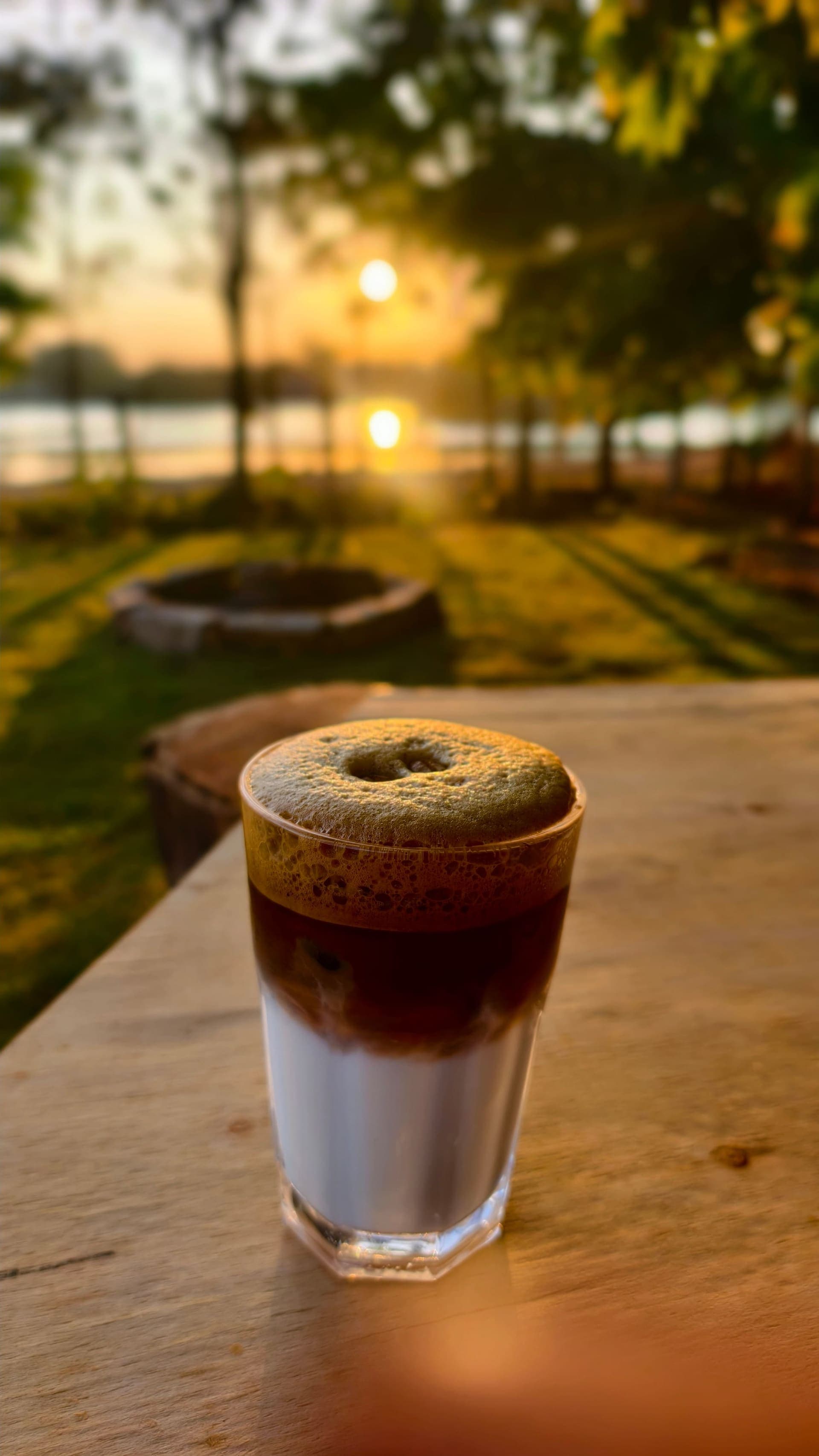 Iced coffee on a table by Kyalasanahalli Lake at golden hour, at the Shack
